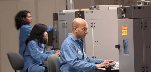四泰公司的工作人员在实验室，穿着蓝色的实验室大褂